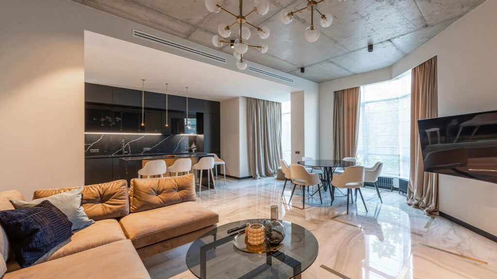 Studio interior with couch near table and chairs near kitchen