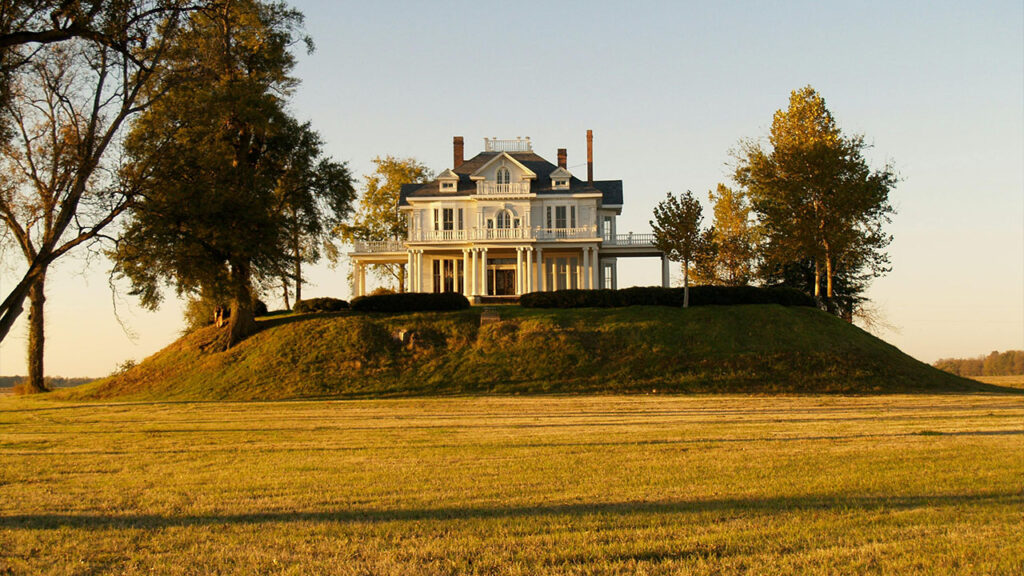 Photo of White and Gray House Near Green Field Surrounded With Trees