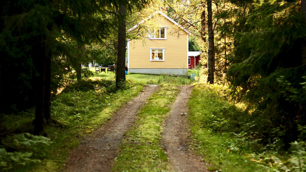 white and brown house surrounded by green trees during daytime
