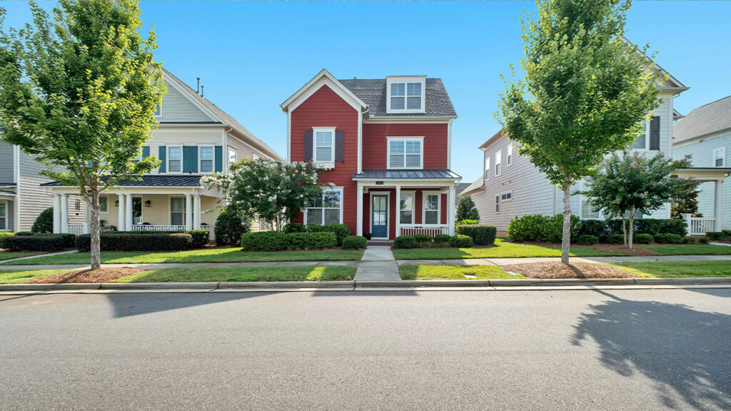 white and brown concrete house near green trees under blue sky during daytime