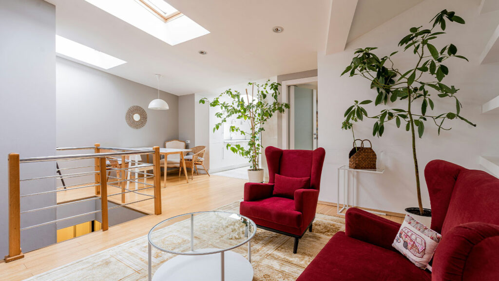 a living room filled with furniture and a skylight