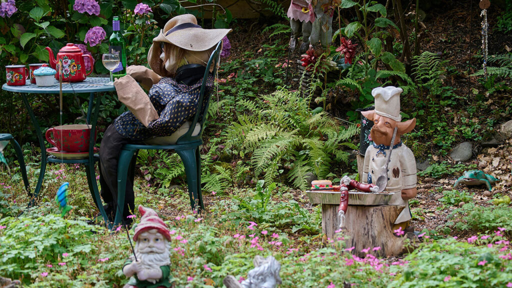 a group of gnomes sitting around a table in a garden