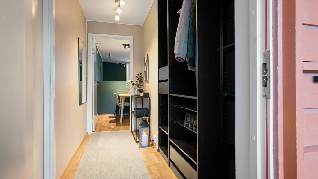 A hallway leading to a bedroom with a closet