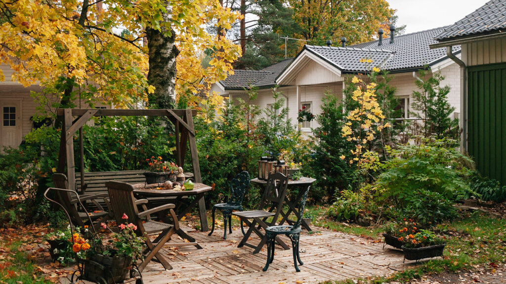 a patio with a table, chairs and a bench