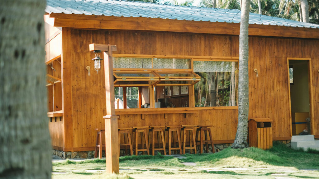 a small wooden building with a bar in front of it