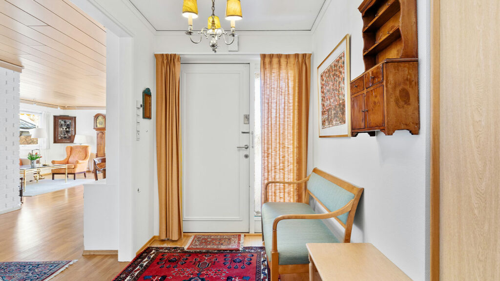 A hallway with a rug and a chair