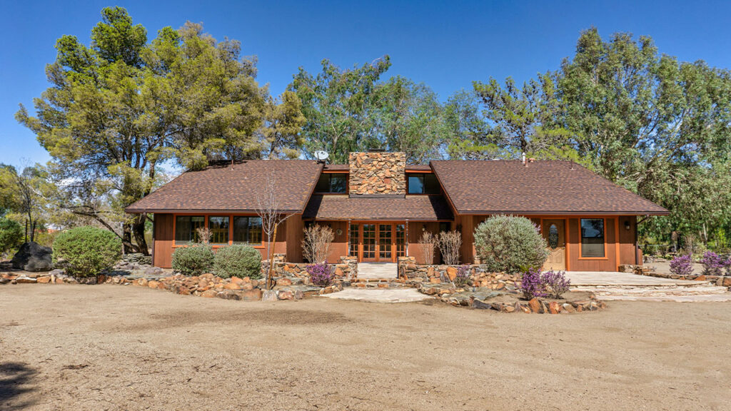 a couple of houses with trees in the back