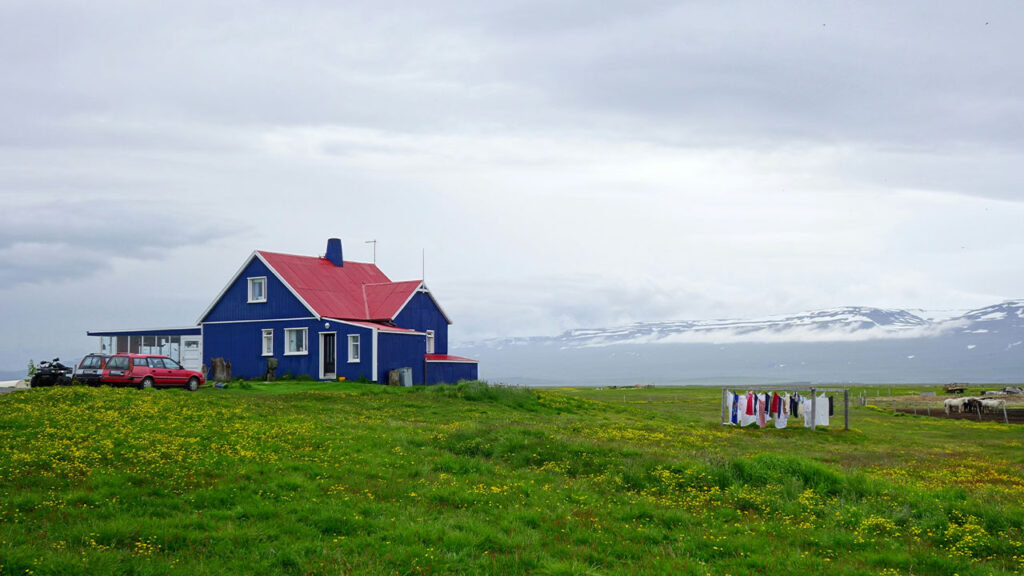 red and white house on green grass field under white clouds during daytime