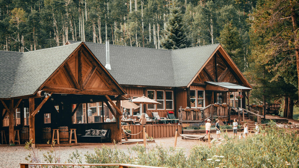 brown wooden house near green trees during daytime