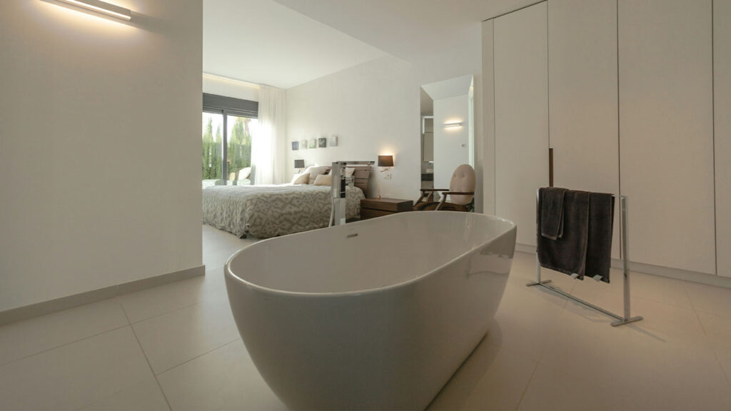 white ceramic bathtub near black textile