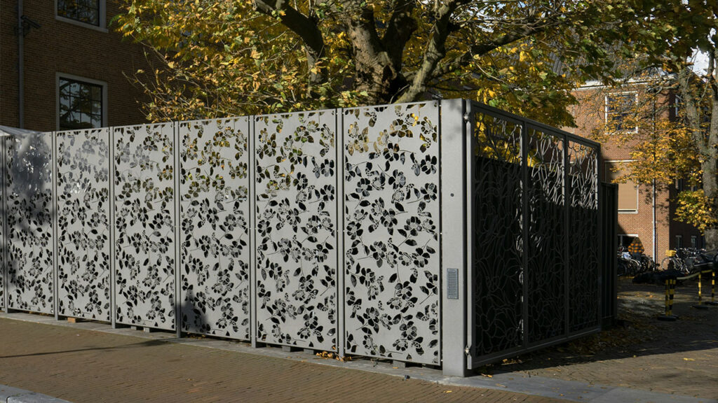 a tall metal fence sitting next to a tree