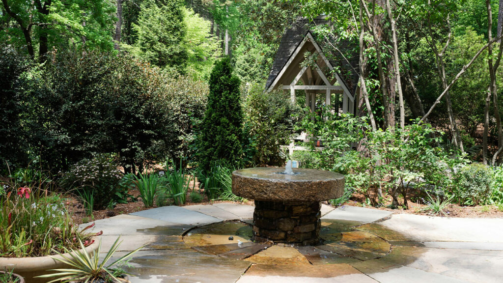 a garden with a fountain in the middle of it
