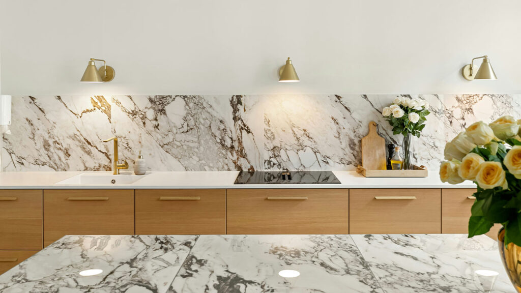 A kitchen with marble counter tops and gold accents
