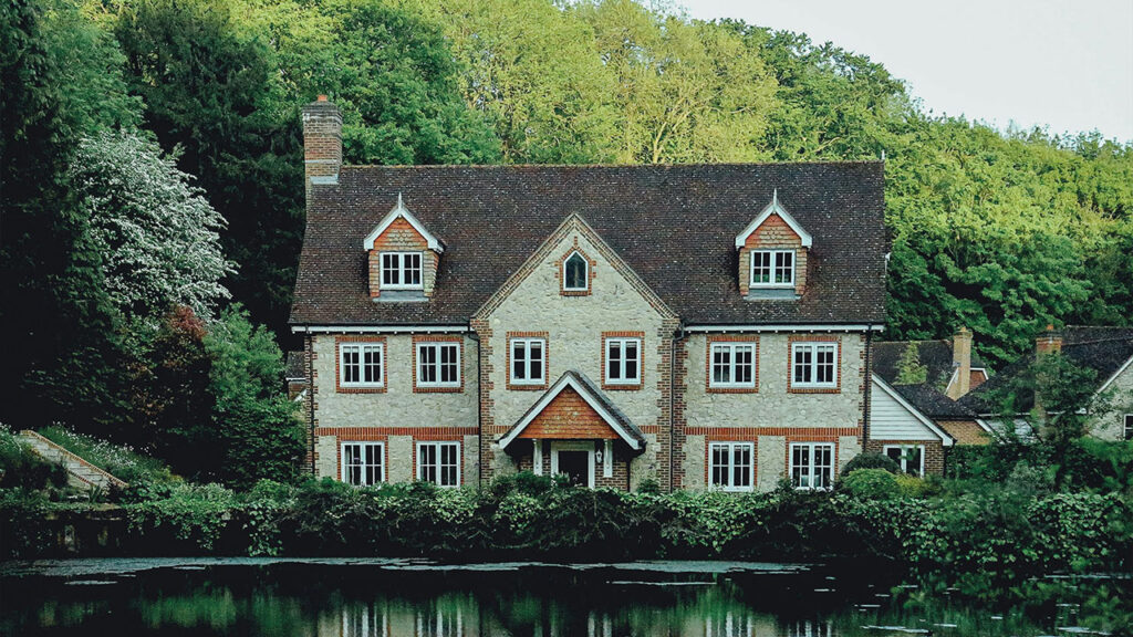 concrete house near a body of water and forest