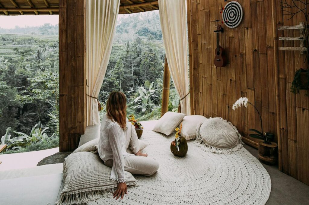 Rachel Claire / Pexels A woman sitting on a rug in a large hut.