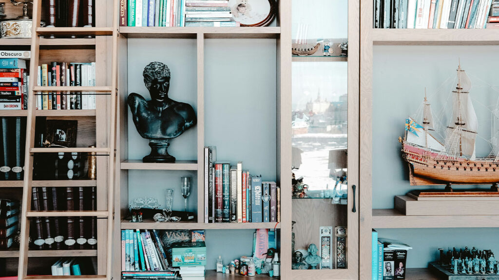 white wooden shelf with books and figurines