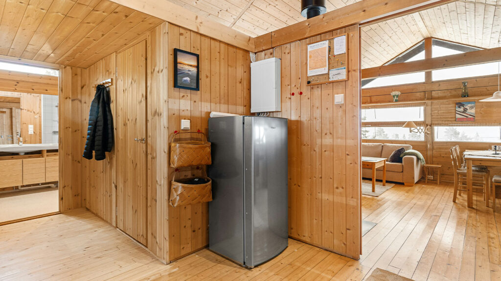A room that has a refrigerator and a table in it