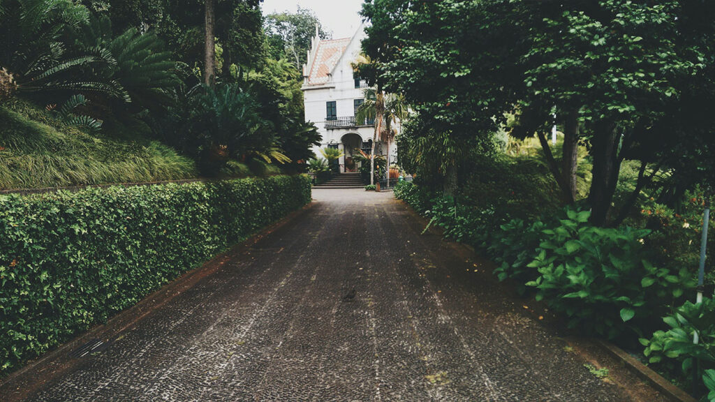 concrete pathway near white concrete storey house near trees at daytime
