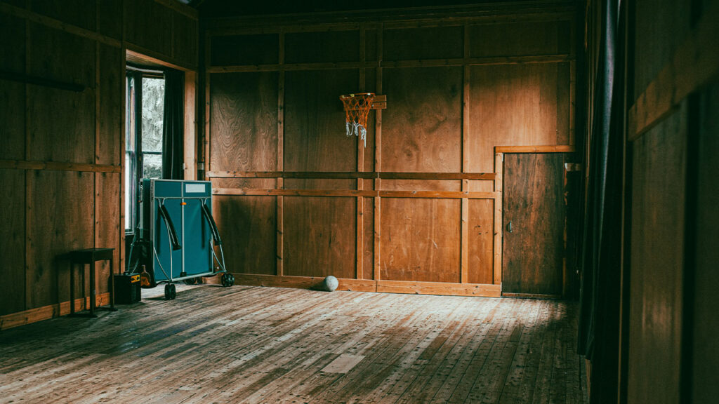 a room with wood paneling and a basketball hoop