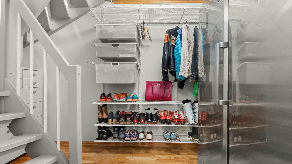 A walk in closet with a lot of shoes