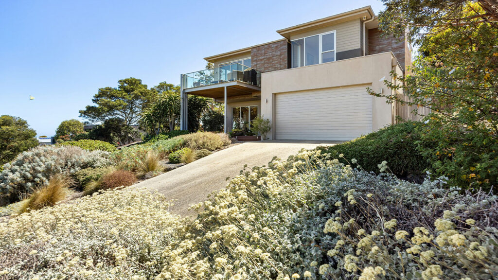 A house with a lot of trees and bushes in front of it