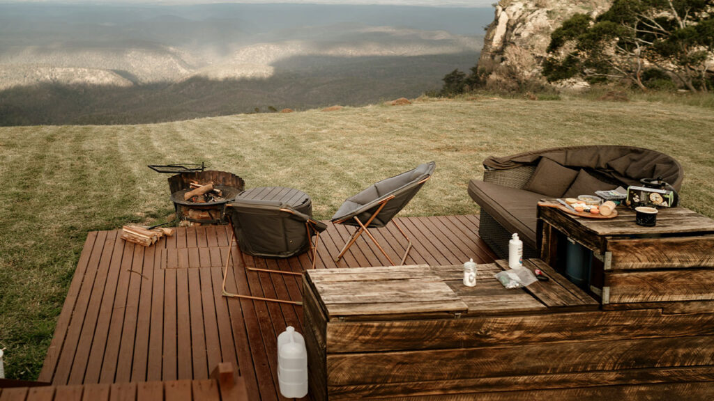 a wooden deck with chairs and a table on it