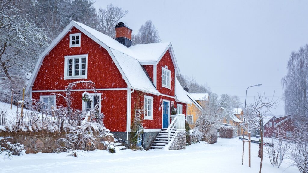 Winter scenery with red wooden house in Sweden