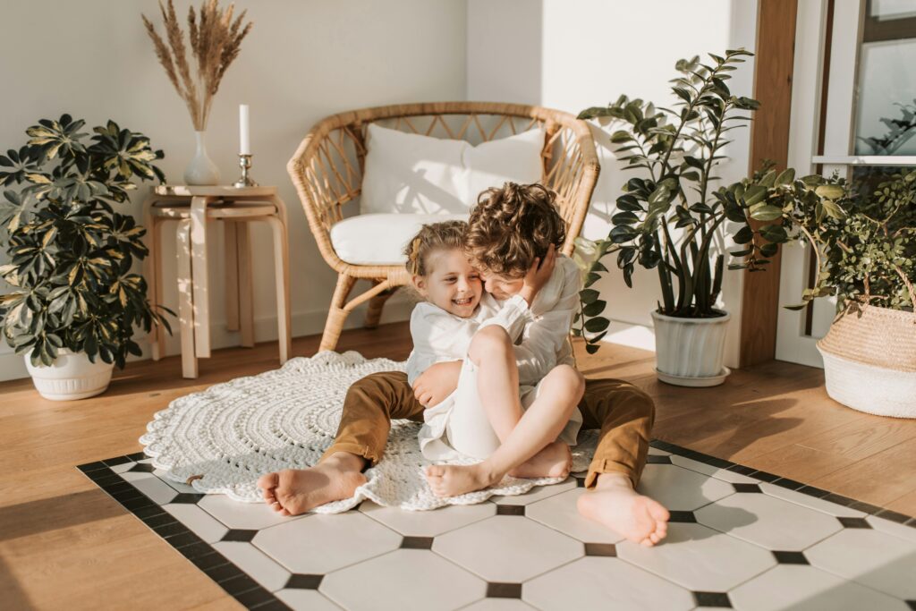 Vlada Karpovich / Pexels Two boys on the floor hugging surrounded by plants.