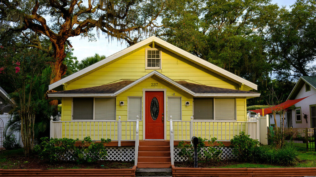 white and yellow wooden house near green trees during daytime