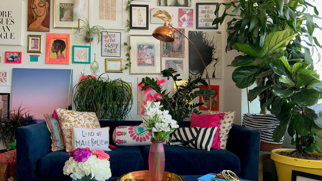 a living room with a blue couch and a vase with flowers