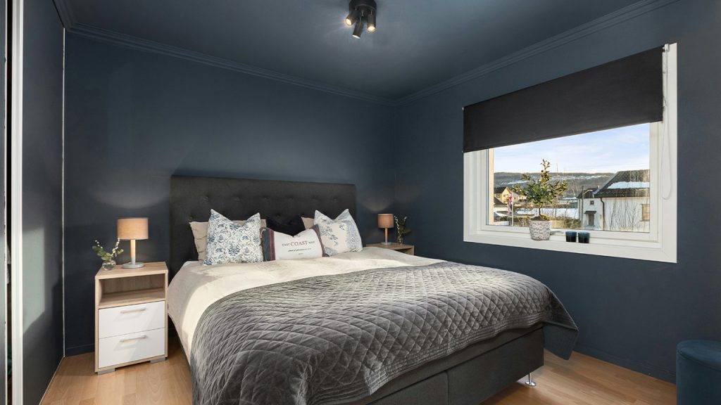A bedroom with blue walls and a large bed