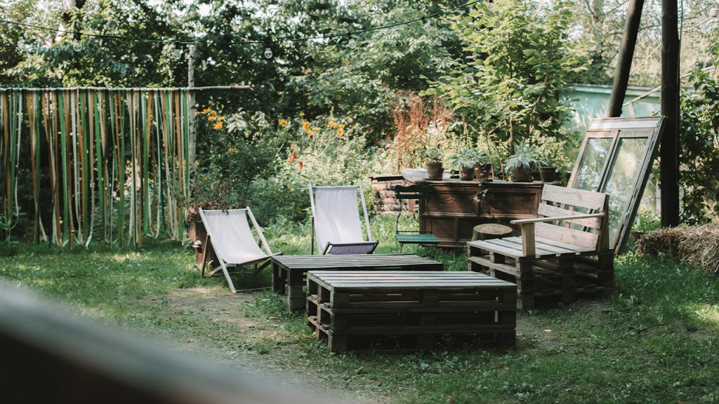 brown wooden bench near folding chairs and wood pallet