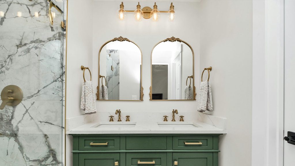 a bathroom with marble counter tops and green cabinets