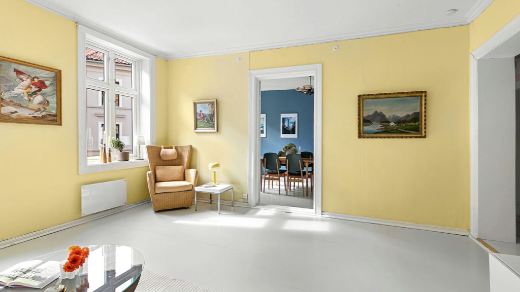A living room with yellow walls and white floors