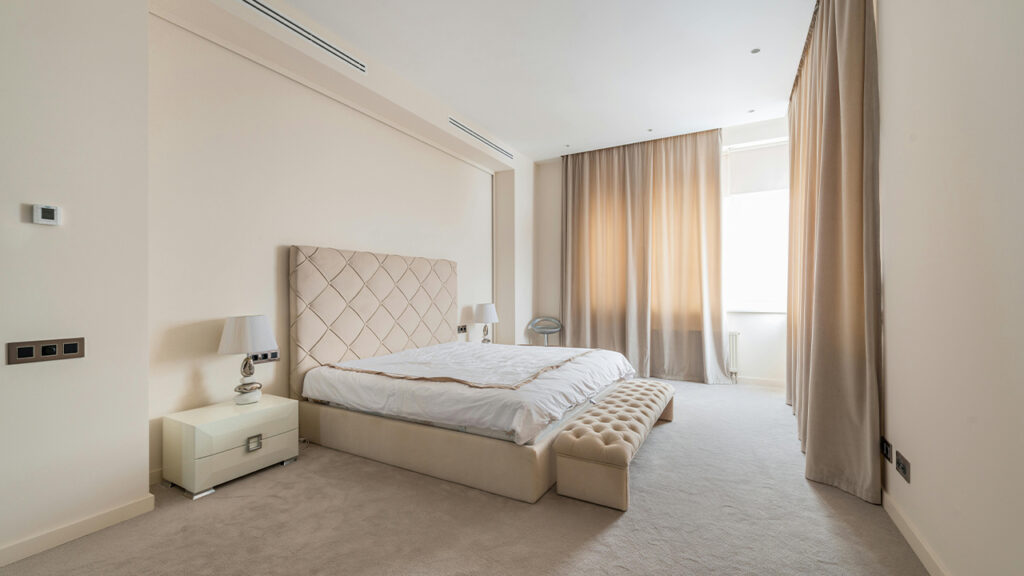 Interior of classy styled bedroom with soft bed and bench