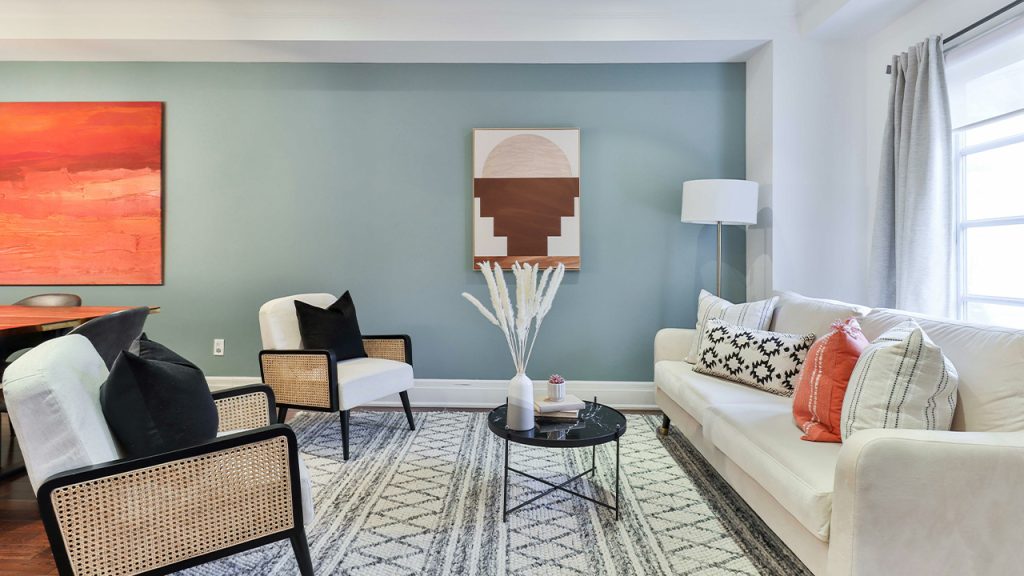 a living room filled with furniture and a painting on the wall