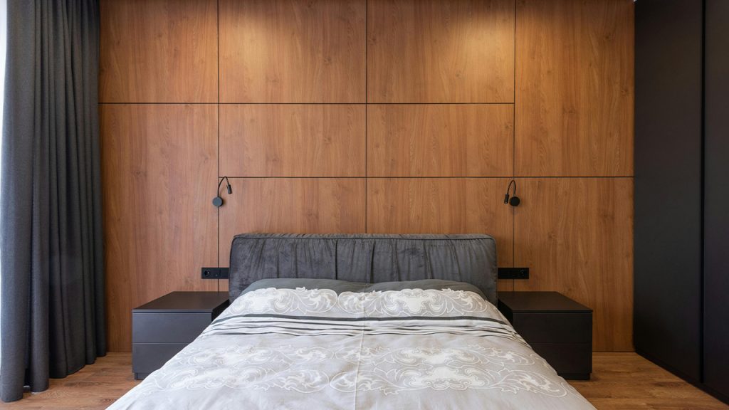 Interior of modern bedroom with soft bed and wooden walls