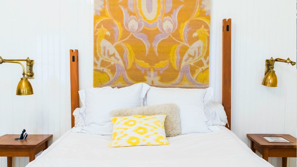 white and brown bed beside wall