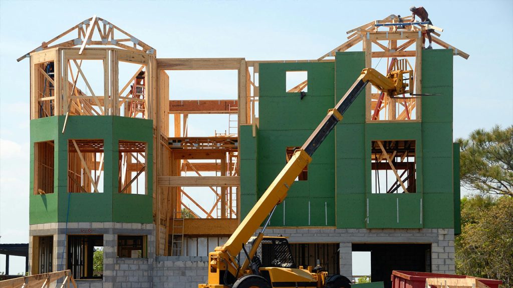 Yellow and Black Heavy Equipment Near Unfinished Building