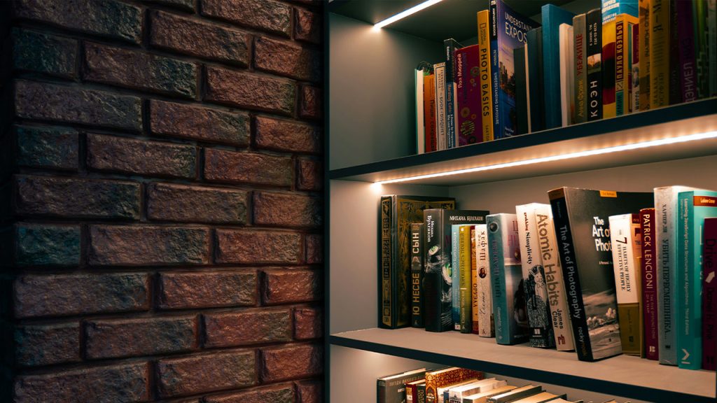 a bookshelf filled with lots of books next to a brick wall