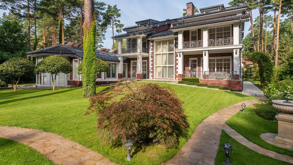 House near plants and trees on lawn