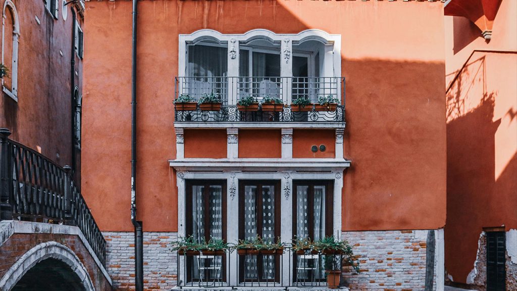 Aged house facade with balconies in city