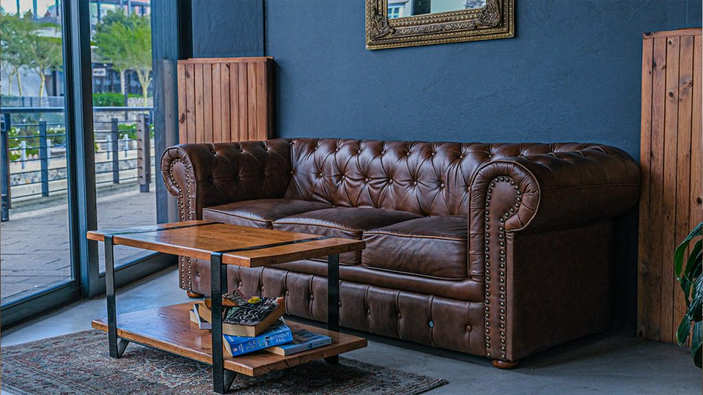 a living room with a brown leather couch and coffee table