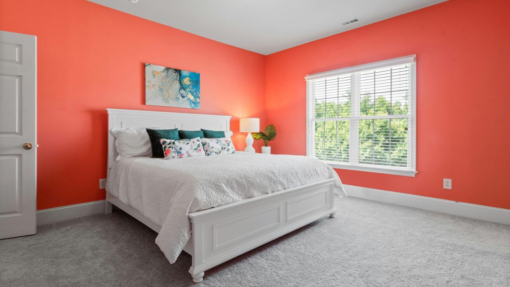 White Bedframe in an Orange Bedroom