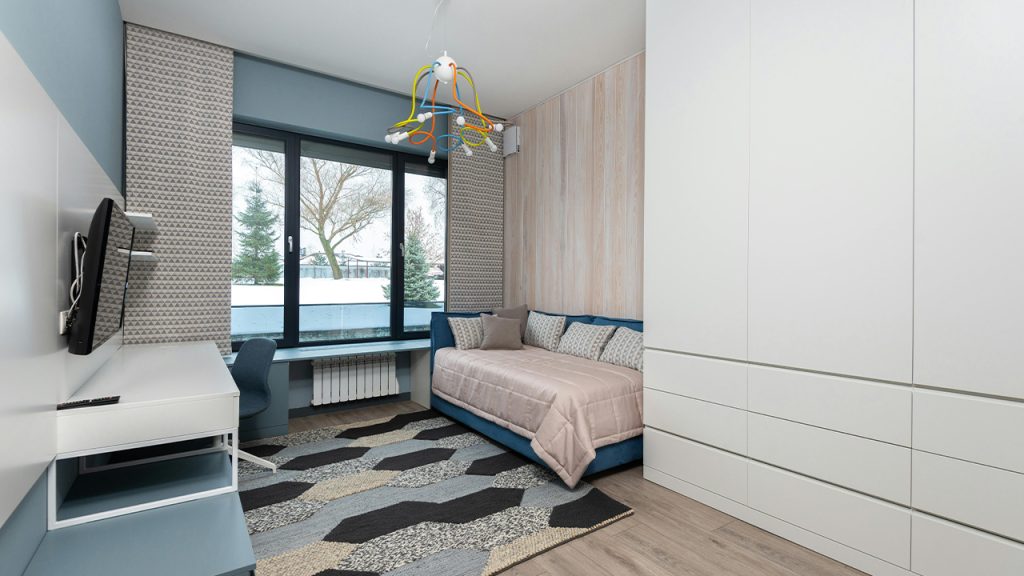 Bedroom with sofa and workspace in modern apartment