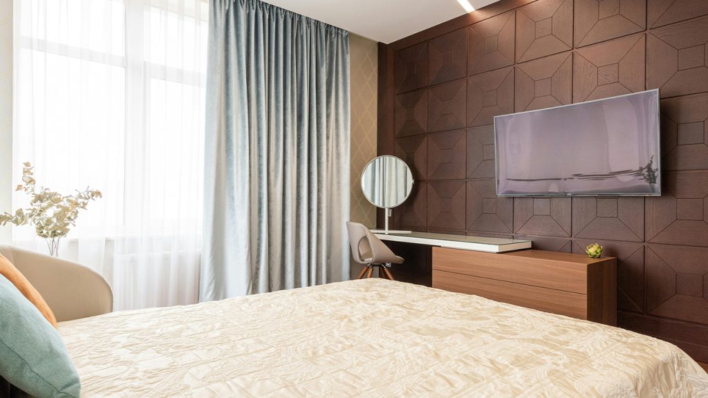 Comfortable bed against wall with TV