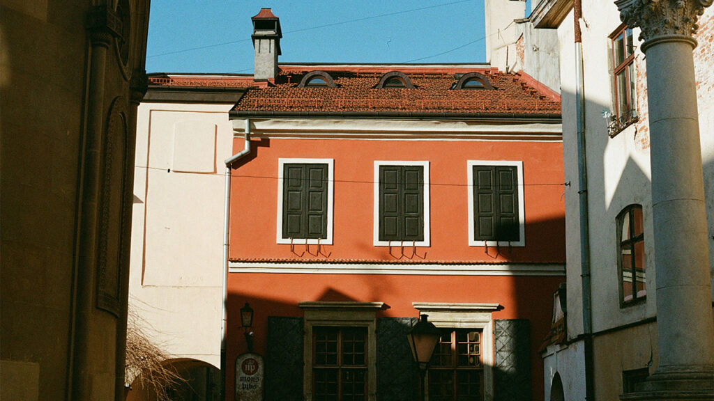 A narrow street with a red building in the background