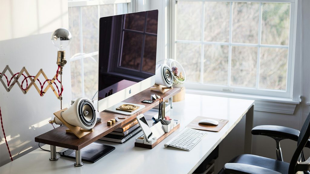 silver iMac on desk near window