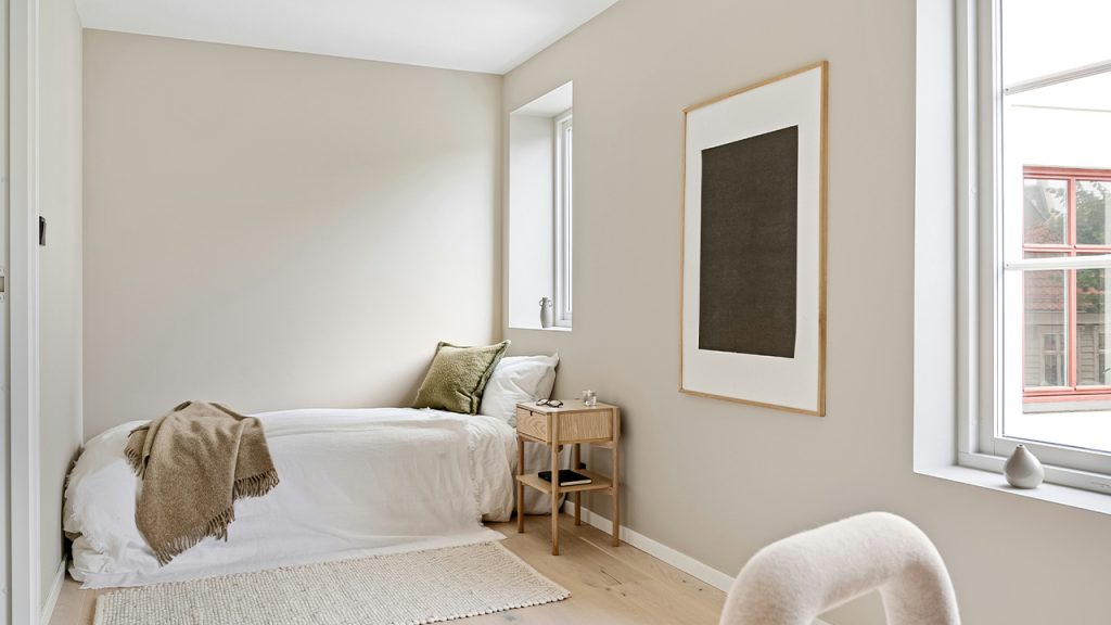 A bedroom with two beds and a chair