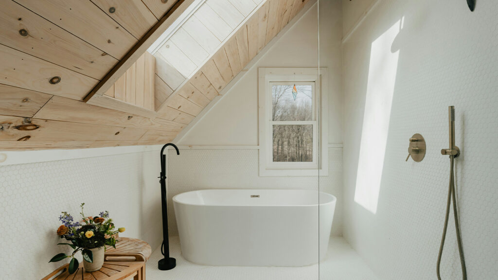 a bathroom with a wooden ceiling and a white bathtub